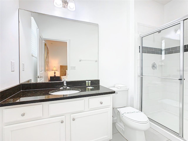 bathroom featuring toilet, tile flooring, a shower with shower door, and vanity