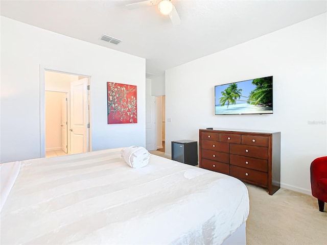 bedroom with light colored carpet, connected bathroom, and ceiling fan