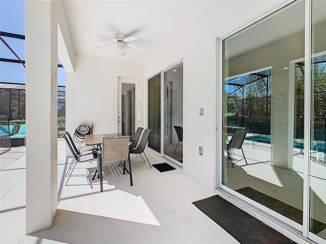 view of patio / terrace featuring a swimming pool, glass enclosure, and ceiling fan