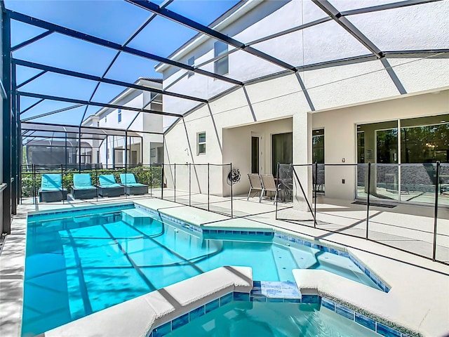 view of swimming pool with a patio area, an in ground hot tub, and glass enclosure