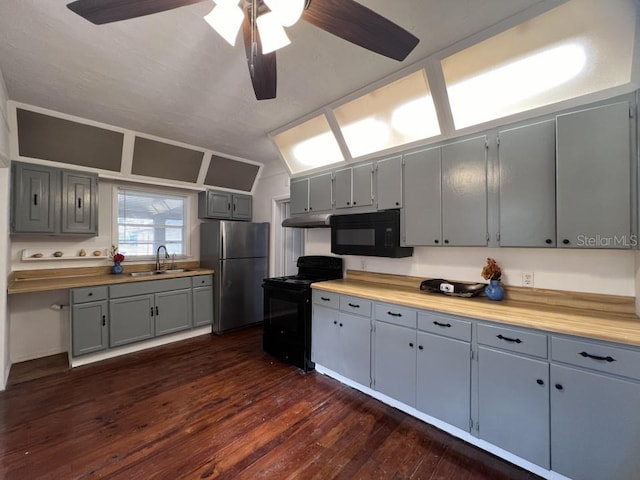 kitchen with wood counters, sink, black appliances, ceiling fan, and dark hardwood / wood-style flooring