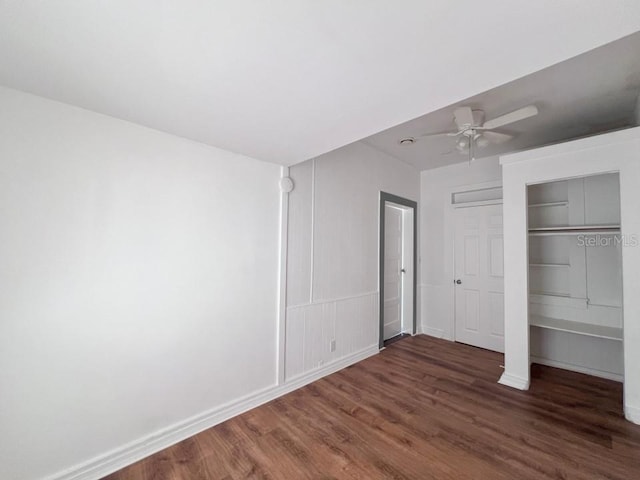 unfurnished bedroom featuring dark wood-type flooring, a closet, and ceiling fan