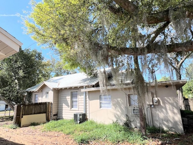 view of side of home with a deck and central AC unit