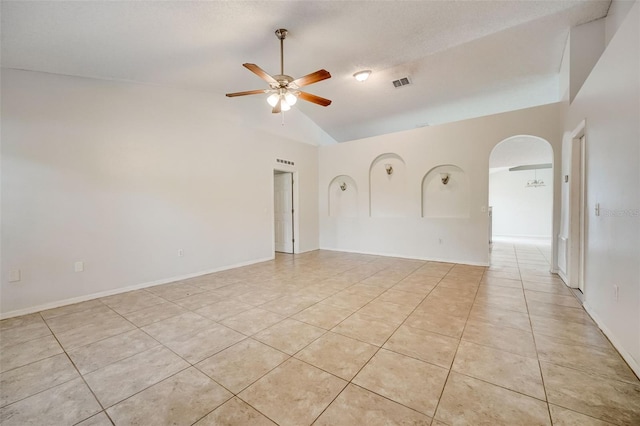 tiled empty room with high vaulted ceiling and ceiling fan