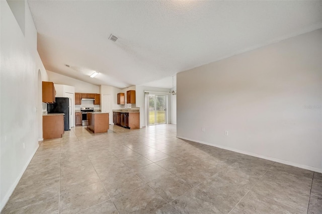 unfurnished living room featuring lofted ceiling and light tile floors