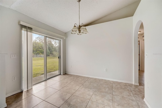 tiled empty room with a textured ceiling, vaulted ceiling, and an inviting chandelier