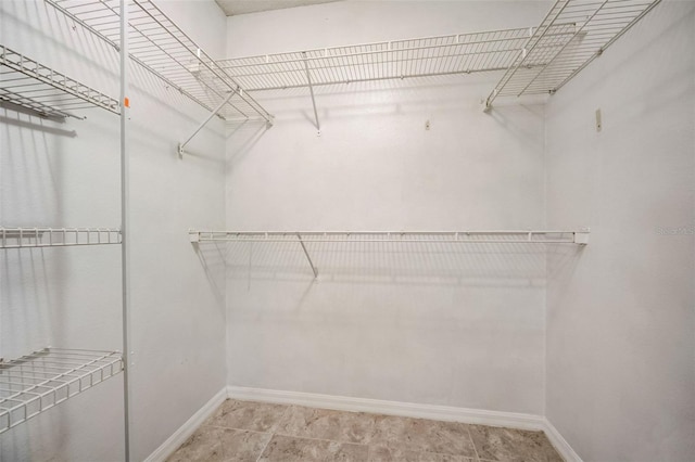 walk in closet featuring light tile floors