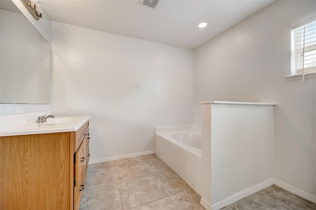 bathroom featuring a washtub, tile floors, and vanity