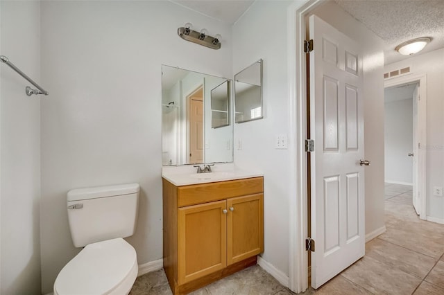 bathroom featuring toilet, tile flooring, a textured ceiling, and large vanity