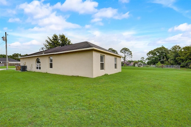 back of house featuring a yard and central air condition unit