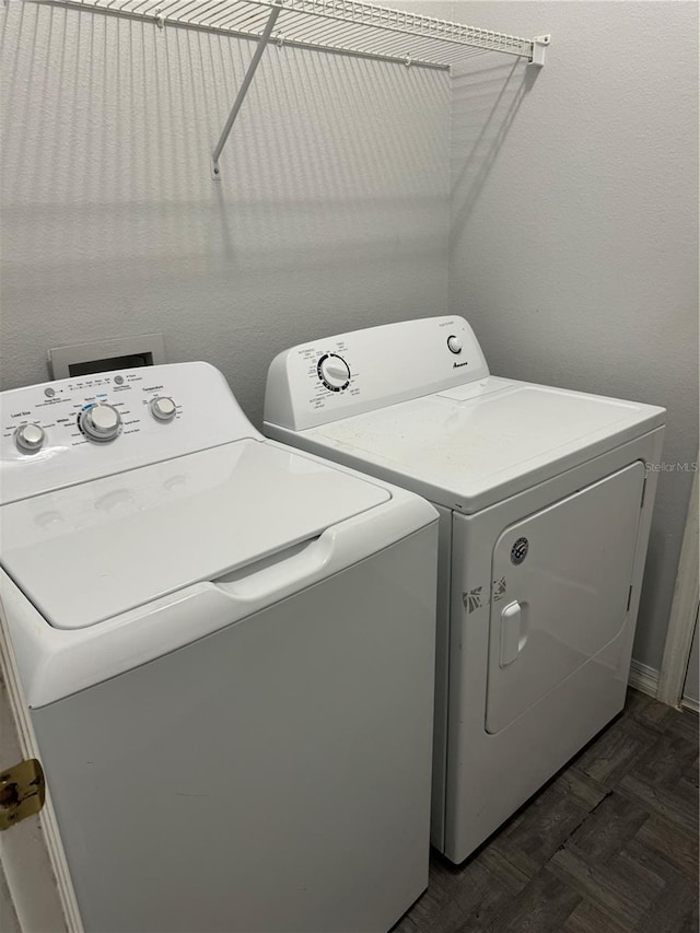 laundry area with separate washer and dryer and dark parquet flooring