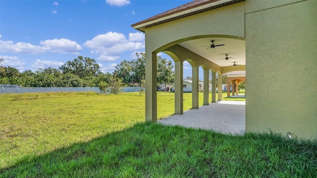 exterior space with a patio, a water view, and a lawn