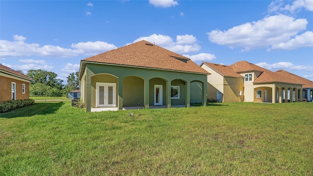 rear view of property with a lawn and french doors