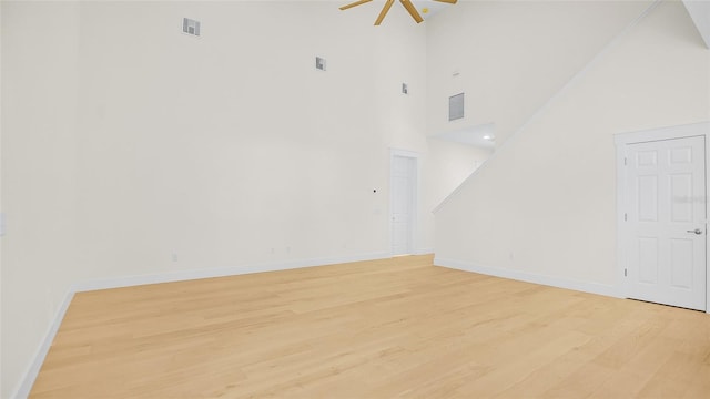 unfurnished living room with light hardwood / wood-style floors and high vaulted ceiling