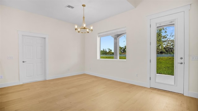 unfurnished dining area featuring light hardwood / wood-style flooring and a chandelier