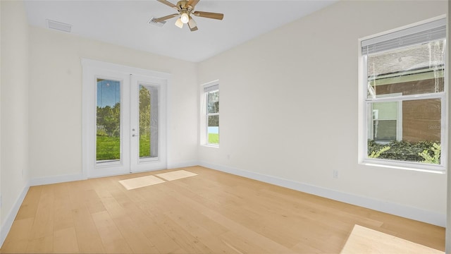 unfurnished room featuring french doors, light wood-type flooring, and ceiling fan