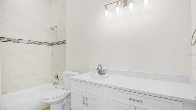 full bathroom featuring tiled shower / bath, vanity, and toilet