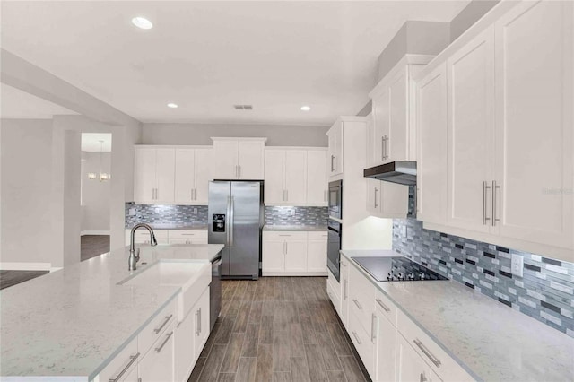 kitchen featuring white cabinets, light stone countertops, tasteful backsplash, and black appliances