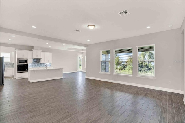 unfurnished living room featuring dark hardwood / wood-style flooring and sink