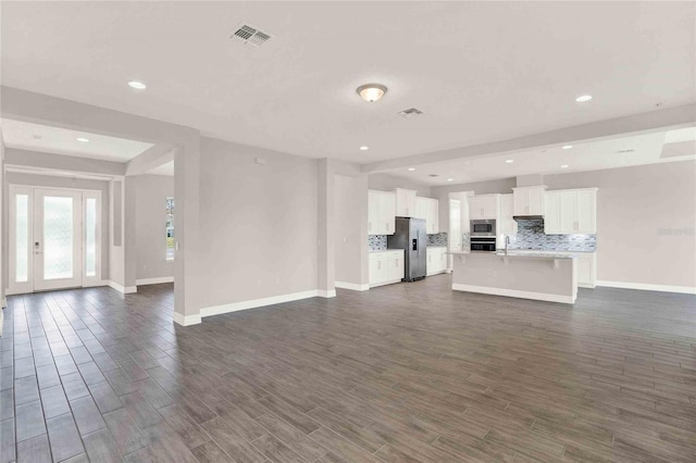 unfurnished living room with sink and dark hardwood / wood-style flooring