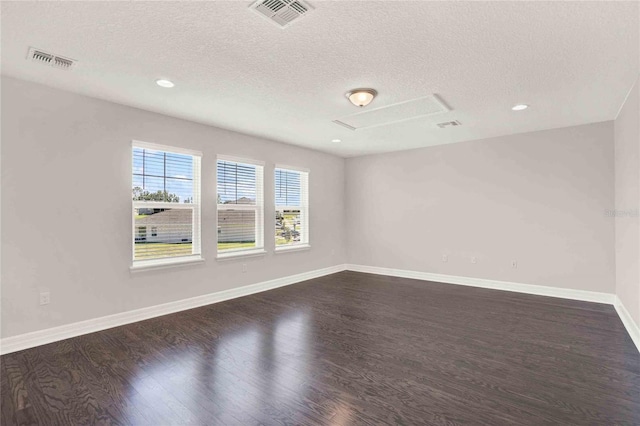 unfurnished room featuring dark wood-type flooring and a textured ceiling