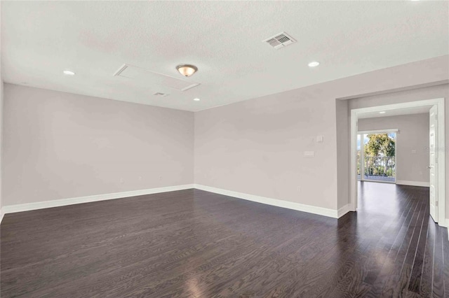 unfurnished room with a textured ceiling and dark hardwood / wood-style floors