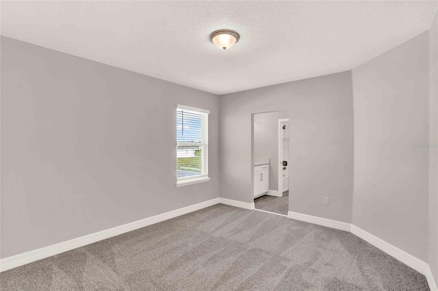 carpeted spare room with a textured ceiling