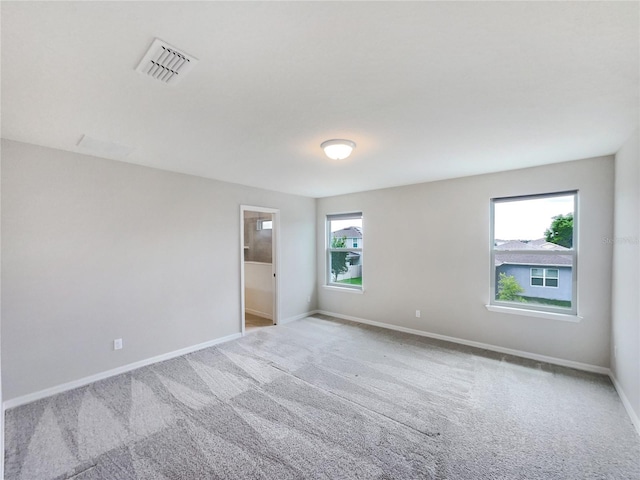 carpeted spare room featuring plenty of natural light