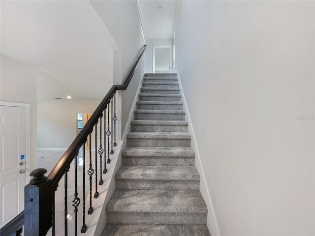 staircase with dark colored carpet