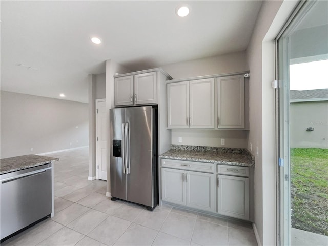 kitchen with light tile flooring, stone counters, gray cabinets, and appliances with stainless steel finishes