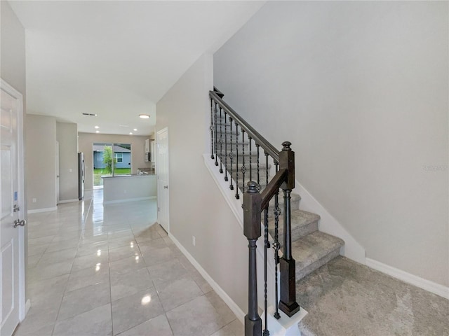 staircase featuring light tile floors