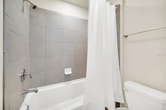 bathroom featuring shower / bath combination with curtain and toilet