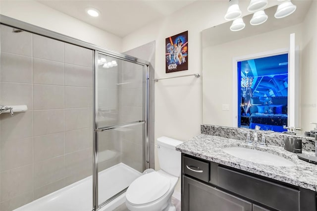 bathroom with vanity, toilet, and a shower with shower door