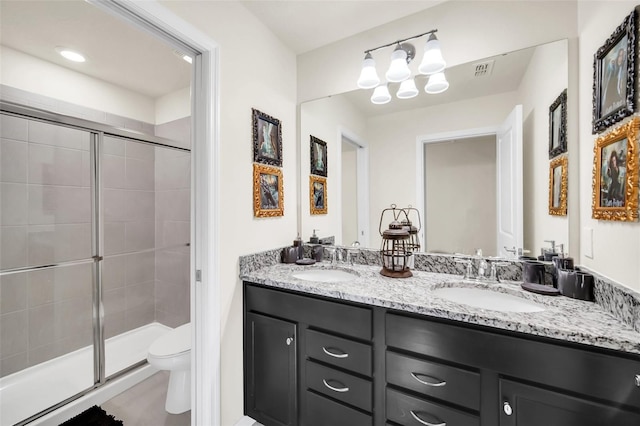 bathroom featuring vanity, toilet, and a shower with shower door