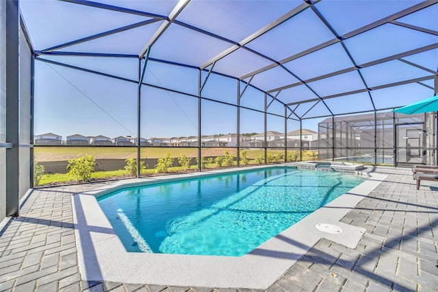 view of swimming pool with a patio area, an in ground hot tub, and glass enclosure