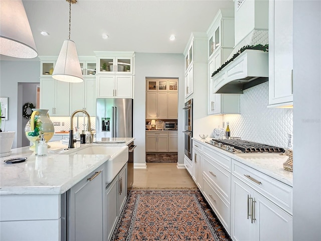 kitchen featuring a center island with sink, white cabinetry, pendant lighting, and appliances with stainless steel finishes