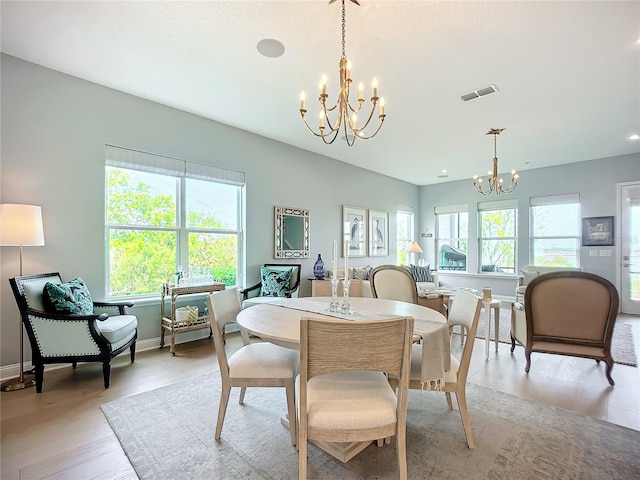 dining room with an inviting chandelier and light wood-type flooring