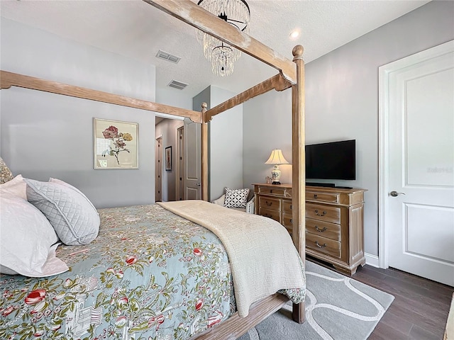 bedroom featuring a textured ceiling and dark hardwood / wood-style flooring