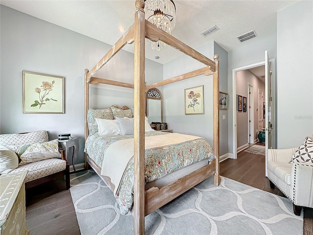 bedroom featuring a textured ceiling and dark hardwood / wood-style flooring