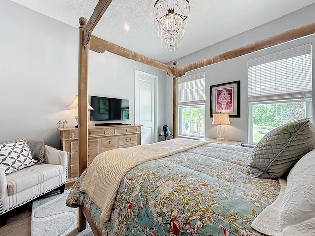 bedroom featuring a textured ceiling, multiple windows, and a chandelier