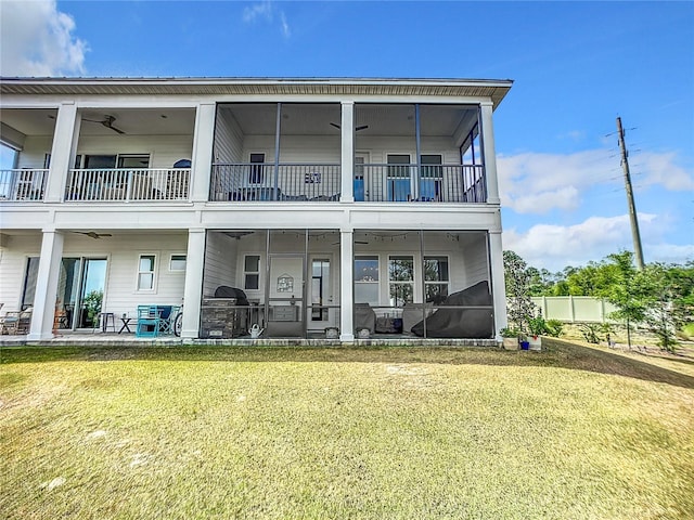 back of property with a lawn, a patio area, and a sunroom