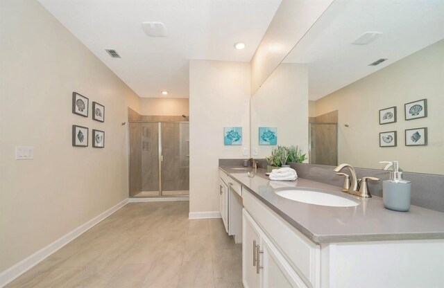 bathroom with an enclosed shower, oversized vanity, and dual sinks