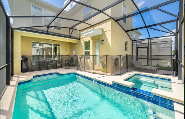 view of pool featuring an in ground hot tub, glass enclosure, and a patio