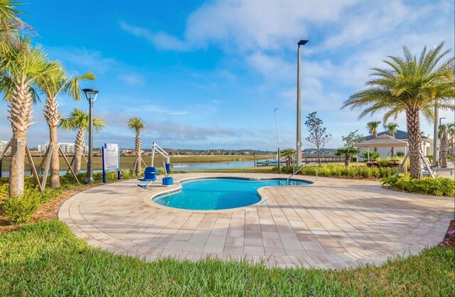 view of swimming pool with a gazebo, a water view, and a patio area