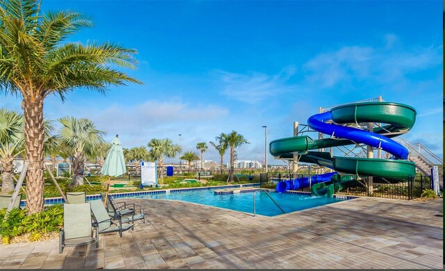 view of pool with a patio and a water slide