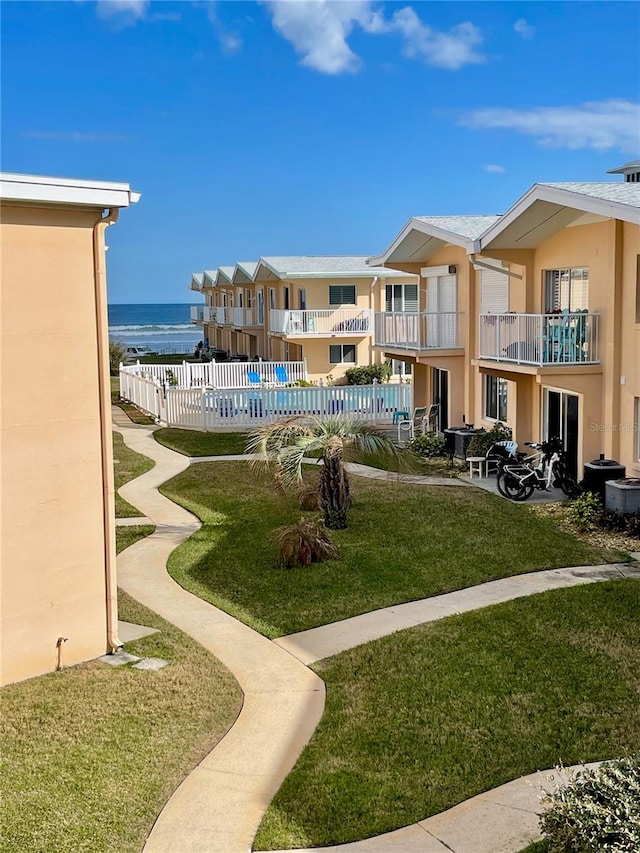 view of home's community featuring a water view and a yard