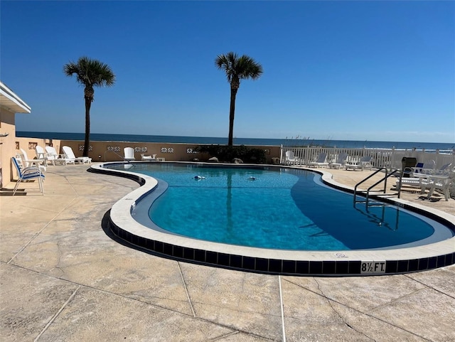 view of swimming pool featuring a patio and a water view