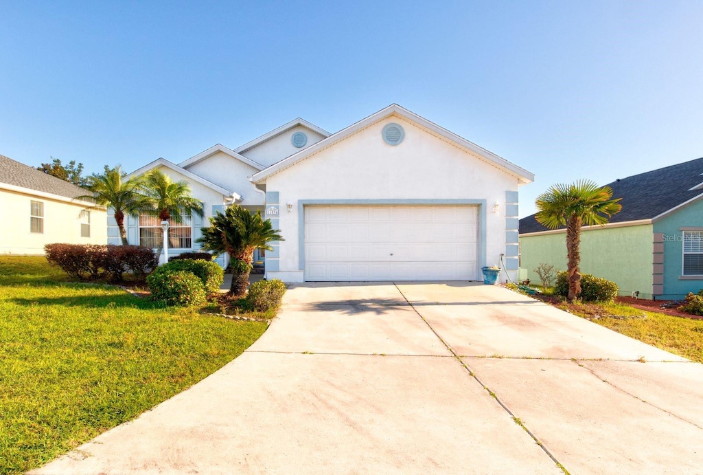 single story home featuring a front lawn and a garage