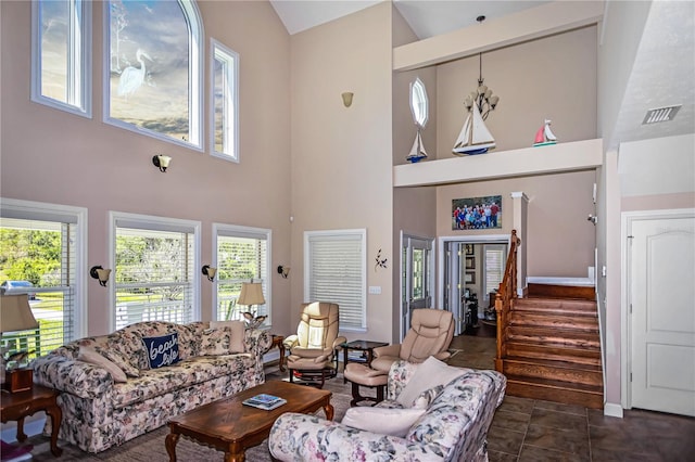 living room with high vaulted ceiling and dark tile floors