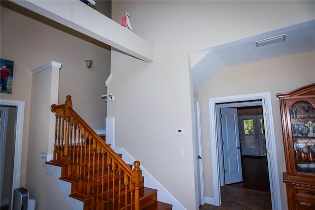 stairway featuring dark tile flooring